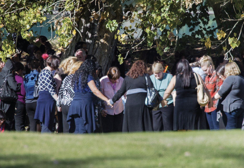 Evacuated workers pray in a circle on the San Bernardino Golf Course across the street where a mass shooting occurred at the Inland Regional Center on December 2, 2015 in San Bernardino, California.