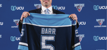 Ben Barr holding up a #5 jersey that reads "BARR" over the number
